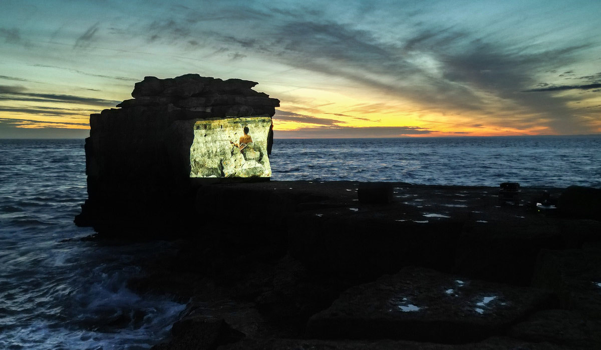 A film projected onto Pulpit Rock at Portland Bill at dusk during the b-side festival